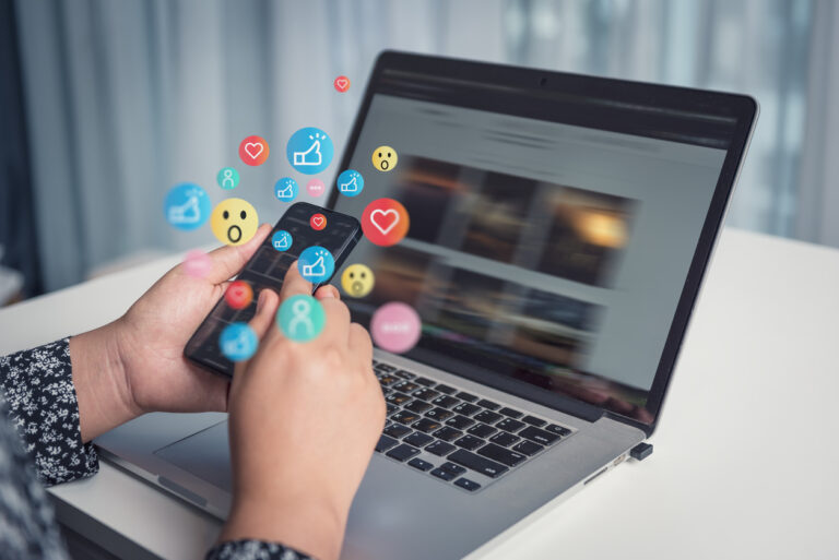 Engagement and emoji reactions coming out of an iphone that is showing a social media feed