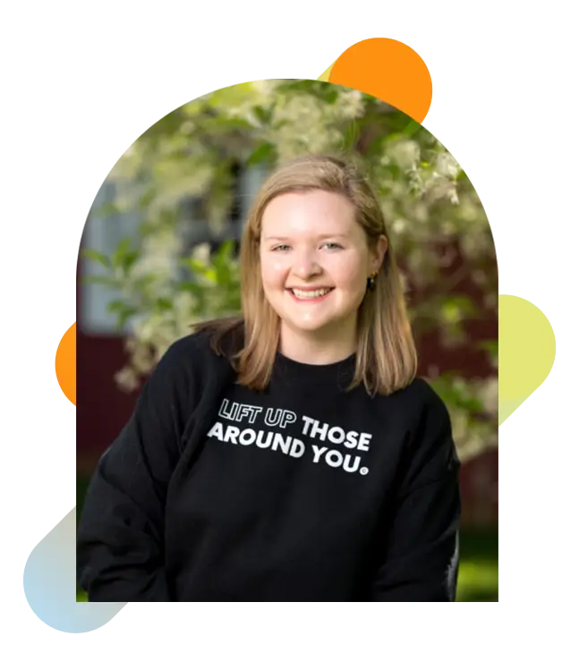 GiveCampus employee wearing a values sweatshirt that says, "Lead with curiosity and empathy."