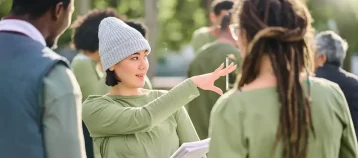 Woman outdoors directing community volunteers.