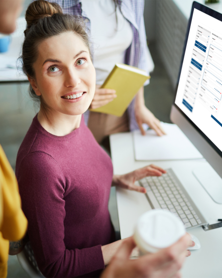 Woman administrator talking to colleague as she builds a custom giving form on the GiveCampus platform.