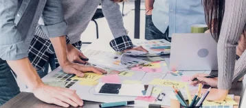 Group of people planning event with papers at desk