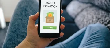 Girl holding smart phone with donation concept on screen