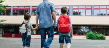 Father walking his two sons into school