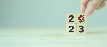 2023 Business common goals and strategies concept. Wooden cubes with text 2023, common goal and strategy icon. Business ecosystem and partnership, team collaboration strategies for goal achievement.