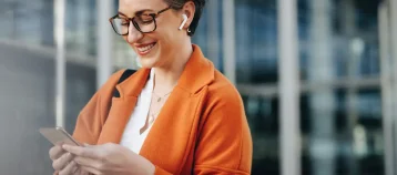 Smiling businesswoman reading a text message on her phone