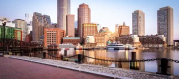 The Boston Harbor and Financial district in Boston, Massachusetts, USA at sunrise showcasing its mix of contemporary and historic buildings.