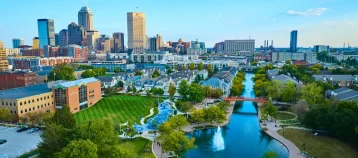 Aerial View of Vibrant Indianapolis Cityscape with Serene Park and Waterway at Golden Hour